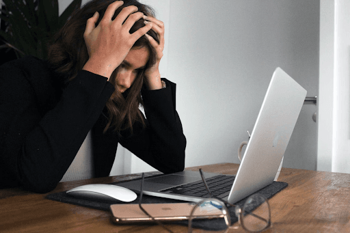 A woman sitting in frustration in front of her laptop